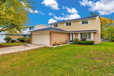 Traditional-style home with concrete driveway, a front yard, and brick siding