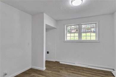 Unfurnished room with wood finished floors and bas