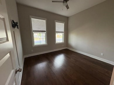 Spare room with ceiling fan and dark wood-style flooring