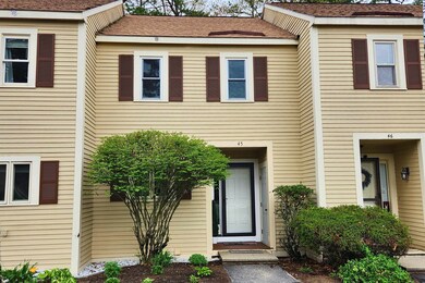 Unit 45, set back between its neighbors, with one of its assigned parking spaces in view.
