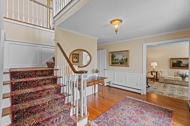 Flanked by formal living and dining rooms with custom millwork throughout