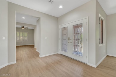 Entrance foyer with french doors, light wood-style