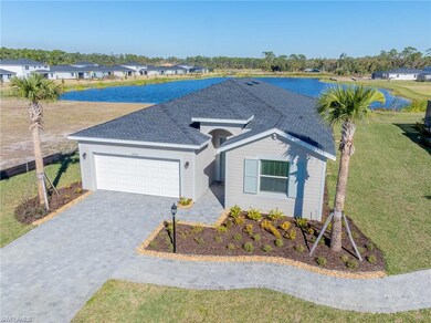 Ranch-style house with a garage, decorative driveway, a front lawn, and a water view
