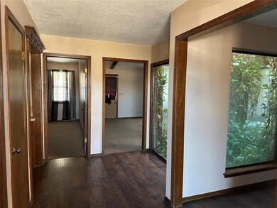 Corridor with dark wood-style floors, baseboards, 