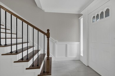 Entrance foyer with wainscoting, ornamental moldi