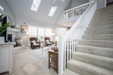 Two story ceiling in the living room with sky lights, new paint and corner gas fireplace.