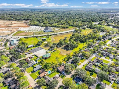 This aerial photo focuses right behind the property. The area is surrounded by greenery and open spaces, providing a serene, residential feel.