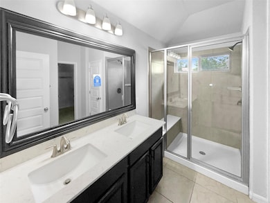 Bathroom with lofted ceiling, tile patterned floo