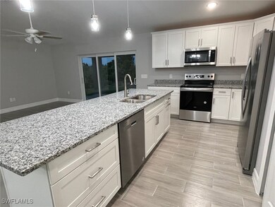 Kitchen featuring a kitchen island with sink, appl
