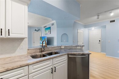 Kitchen with stainless steel dishwasher, light woo