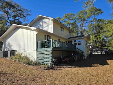 Rear view of house featuring a wooden deck and cen