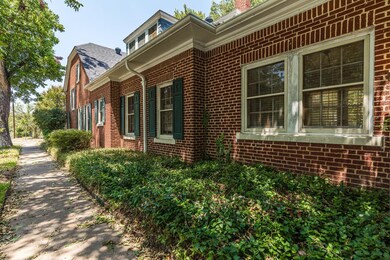 Side of home on corner lot with towering trees