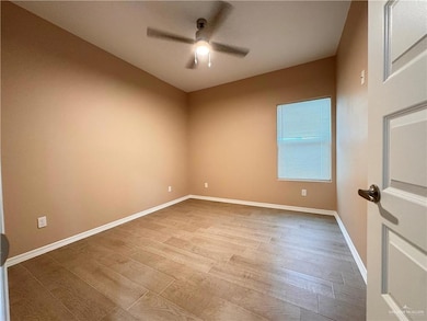 Empty room with ceiling fan and hardwood / wood-style flooring