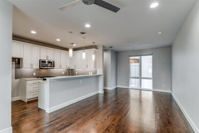 Kitchen featuring hanging light fixtures, dark har