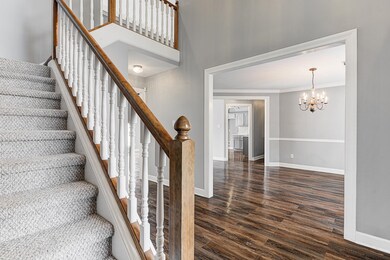 Stairway featuring ornamental molding, a chandelie