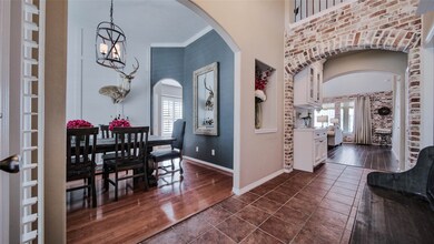 The entry hall showcases this gorgeous exposed brick that is carried into the living room creating a seamless but unique flow through the home. Also pictured here is the all white, custom built china case!