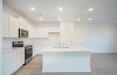 ***Photo from another townhouse recently completed in community with same finishes***

The Kitchen will feature white cabinetry, quartz countertops, white subway tile backsplash and stainless steel appliances.
