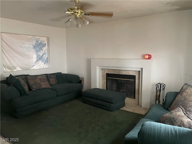 Carpeted living area featuring a tiled fireplace a