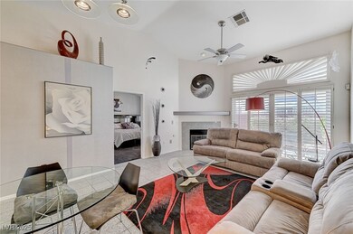 Living room with ceiling fan, a fireplace, and hig