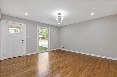 Foyer entrance with baseboards, wood finished floors, and recessed lighting