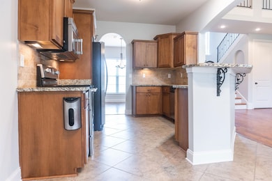 Kitchen featuring light stone counters, a breakfas