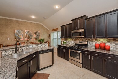 Further down the hallway you have the nice kitchen area. More high ceilings, granite countertops, trendy backsplash and stainless steel appliances.
