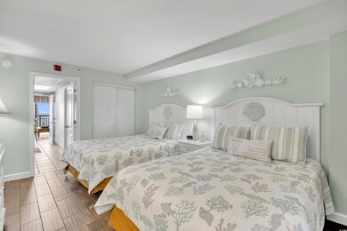 Bedroom with wood finish floors, a closet, and bas