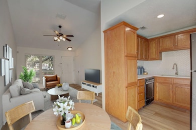 Kitchen with dishwasher, vaulted ceiling, a sink,