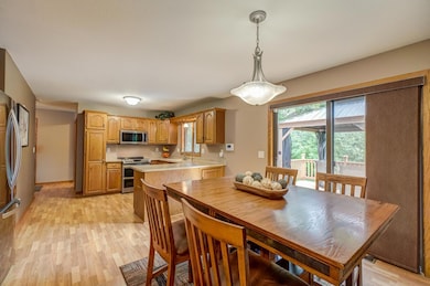 Well-appointed kitchen with updated appliances, a water filtration system, and a Wi-Fi controlled faucet, plus a dining area that opens to a spacious walkout deck featuring a newly added pergola.