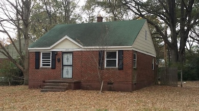 View of front of house featuring crawl space, a chimney, brick siding, and a shingled roof