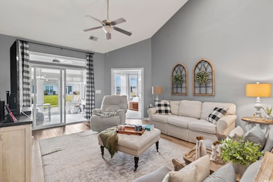 Living area featuring wood finished floors, a ceiling fan, and high vaulted ceiling