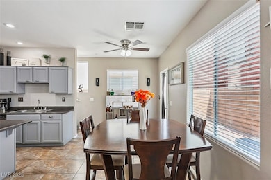 Dining space with a ceiling fan, light tile patter