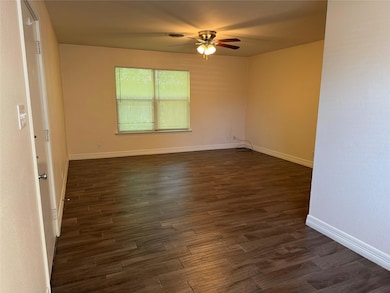 Spare room featuring ceiling fan, dark wood-style