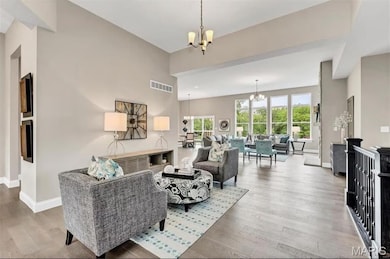 Living area featuring a chandelier and light wood-style floors