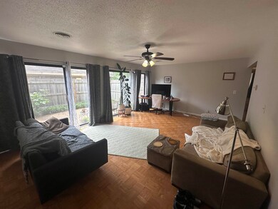 Living room with a textured ceiling, a ceiling fan, and an office area