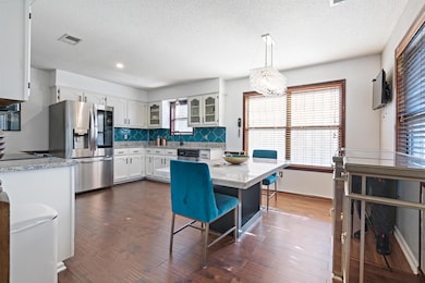 Kitchen featuring dark wood-type flooring, white c