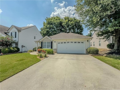 View of front of house featuring an attached garage, driveway, a front yard, and brick siding