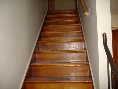 Hardwood staircase with wrought iron railing.