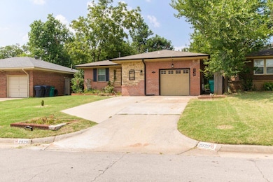 Single story home with a front lawn, driveway, a garage, and brick siding