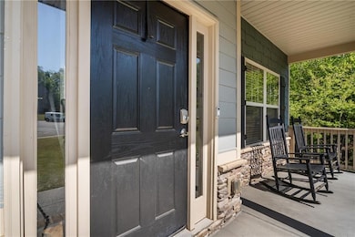 Entrance to property with a porch and stone siding