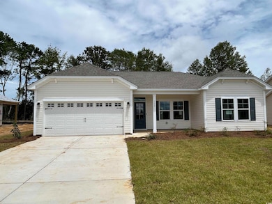 Ranch-style house featuring an attached garage, driveway, a front yard, and a shingled roof