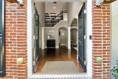 Doorway to property featuring brick siding and a balcony