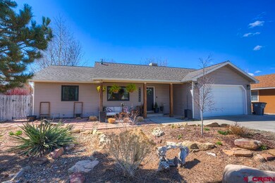 Ranch-style house featuring a shingled roof, fence, a porch, a garage, and driveway