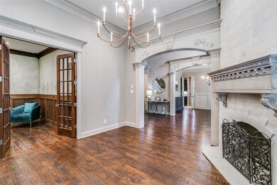 Living room featuring ornamental molding, a notable chandelier, decorative columns, and dark hardwood / wood-style floors