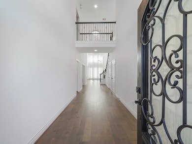 Step inside to a bright and welcoming foyer with soaring ceilings and rich wood flooring that set the tone for this sophisticated home.