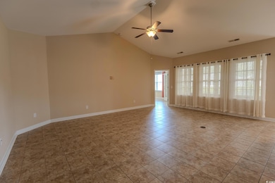 Spare room featuring a ceiling fan, tile patterned flooring, vaulted ceiling, and baseboards