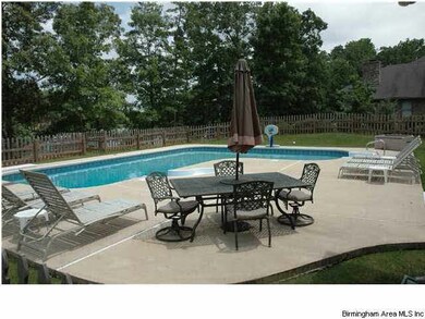 Large pool with diving board and fenced back yard.