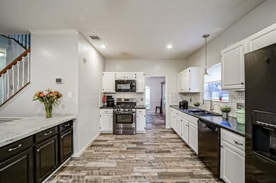 Continue into the kitchen to find recently updated black and stainless appliances that include a 5 burner gas cooktop and single oven, a vent hood microwave, dishwasher, and a dual basin sink with a commercial grade gooseneck pull-down faucet.