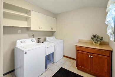 Laundry room featuring tile and shelving