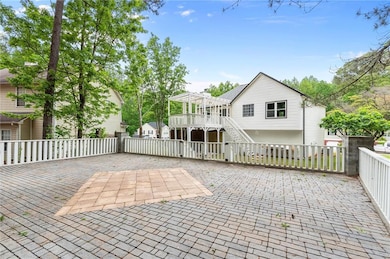 Back of house featuring a pergola, stairs, and fen